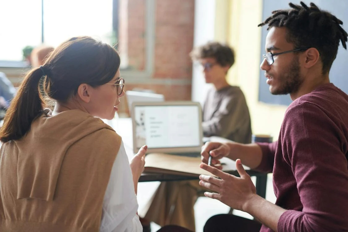 Illustration photo: two business people in discussion face to face in an open plan office