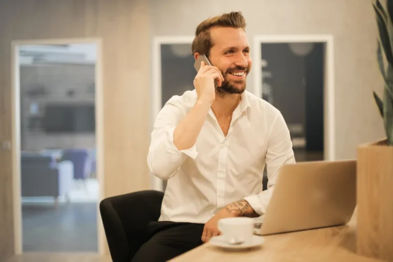 Illustration photo: smiling person on the phone working from a hotel room