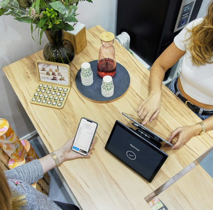 Illustrative photo of someone using a phone to pay at a contactless till in a tea shop
