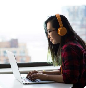 illustrative photo of a developer wearing headphones and working on a laptop